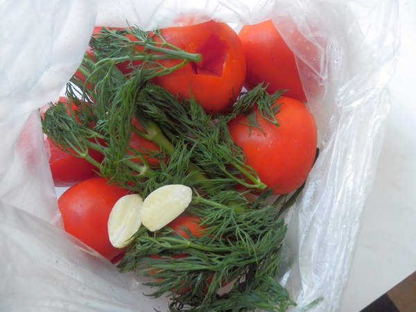 Tomates recién salados en una bolsa y una cacerola